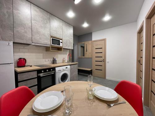 a kitchen with a wooden table and red chairs at Apartment for rent in the city center of Kharkiv K18 Elinaflats in Kharkiv