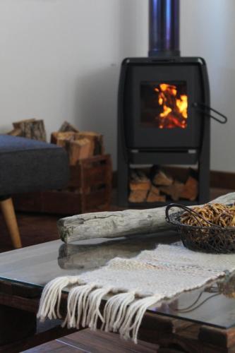 a living room with a fireplace and a table with a towel at Dorotea Vista in Puerto Natales