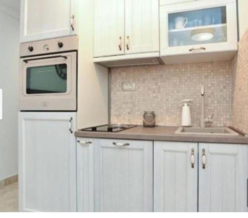 a kitchen with white cabinets and a sink and a microwave at OLD TOWN Budva apart 3 with balcony in Budva