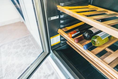 a refrigerator door is open with wine bottles in it at Case Vacanze Il Sogno 2 in Porto Pino