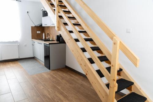 a wooden staircase in a kitchen with a kitchenette at Apartamenty u Jakubika in Krynica Zdrój