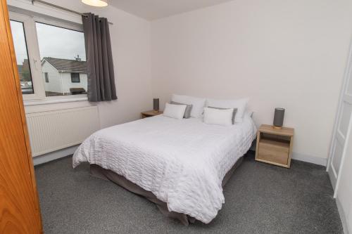 1 dormitorio con cama blanca y ventana en Dwellcome Home Ltd 3 Bedroom Boldon House - see our site for assurance, en Boldon