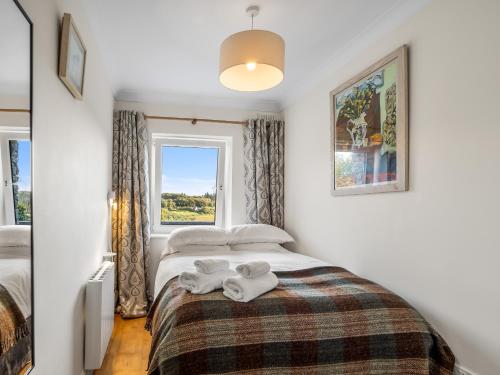 a bedroom with a bed with two towels on it at Clifden Seaview - Spectacular Apartment, Connemara in Clifden