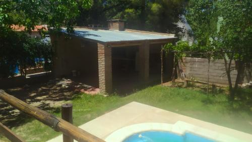 een achtertuin met een huis en een zwembad bij Casa Mis Viejos in Potrero de los Funes