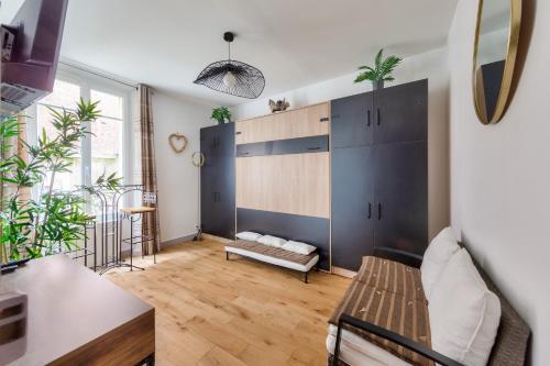 a living room with a couch and a cabinet at Agréable studio proche Paris et Porte de Versailles in Malakoff
