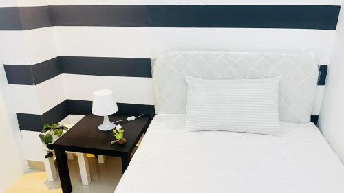 una camera con letto e tavolo con lampada di Fashion Partition Room Near Mall of The Emirates a Dubai