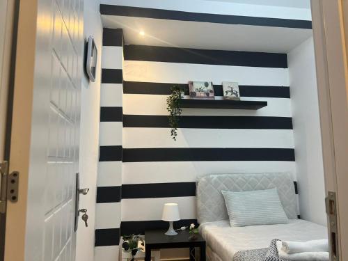 a bedroom with black and white stripes on the wall at Fashion Partition Room Near Mall of The Emirates in Dubai