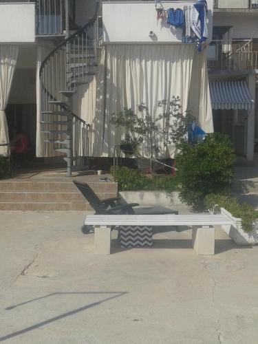 a bench sitting in front of a building with stairs at Apartments Toma Bajnice Directly in Krilo