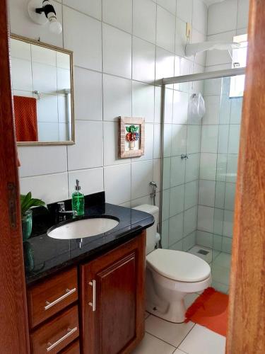 a bathroom with a sink and a toilet and a mirror at Flat Sol do Ipanema in Itacaré