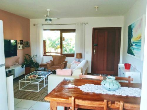 uma sala de estar com uma mesa e um sofá em Flat Sol do Ipanema em Itacaré