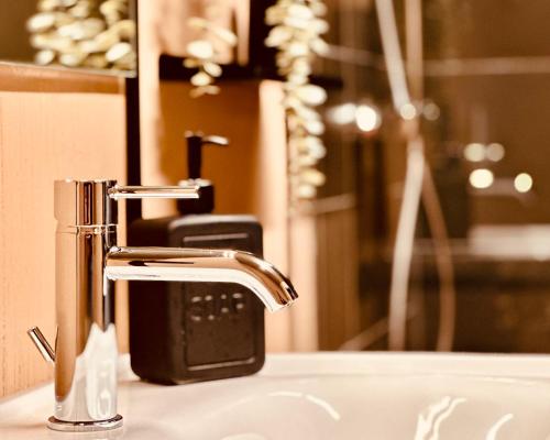a bathroom sink with a faucet and a mirror at Stadthaus Neckarsulm serviced apartments – Stadthaus Heiner in Neckarsulm
