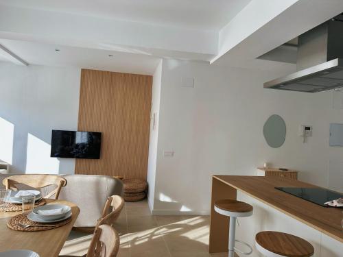 a kitchen and dining room with a table and chairs at Apartament a Palamós amb plaça de parking in Palamós