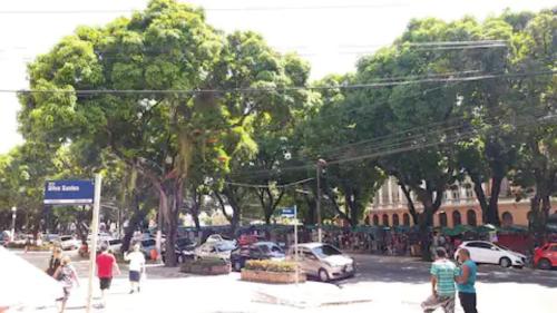 een groep mensen die met auto's over een straat lopen bij Tropical Suítes-Próx Praça da República in Belém