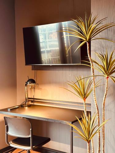 a room with a chair and a television on a wall at Stadthaus Neckarsulm serviced apartments – Stadthaus Heiner in Neckarsulm