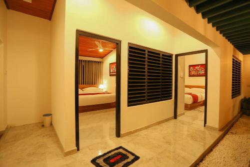 a room with a mirror and a bedroom with a bed at Thisath Villa in Gonapinuwala West