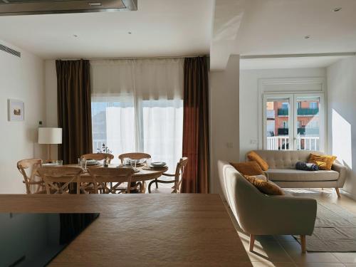 a living room with a couch and a dining room table at Apartament a Palamós amb plaça de parking in Palamós