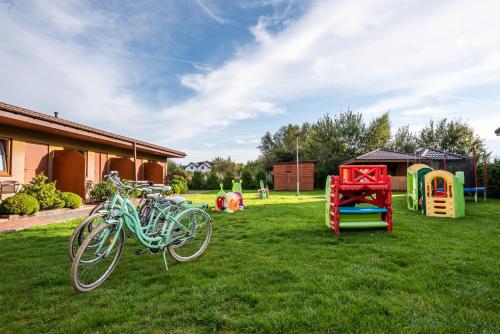 a group of bikes parked in a yard at Rajska Mierzeja , SAUNA , JAKUZZI ,BASEN Z PODGRZEWANĄ WODĄ , KLIMATYZACJA-OGRZEWANIE , PLAC ZABAW , ROWERY , TARAS in Sarbinowo
