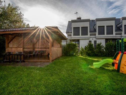 a backyard with a house and a playground at Rajska Mierzeja , SAUNA , JAKUZZI ,BASEN Z PODGRZEWANĄ WODĄ , KLIMATYZACJA-OGRZEWANIE , PLAC ZABAW , ROWERY , TARAS in Sarbinowo