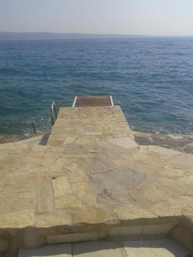 a stone pier with the ocean in the background at Apartments Toma Bajnice Directly in Krilo