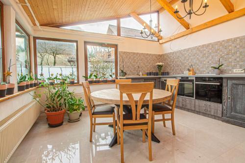 a kitchen with a table and chairs and windows at RunCa-n Rai in Cristian