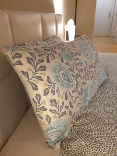 a pillow on a bed with a floral pattern on it at Piccolo Hotel Olina in Orta San Giulio