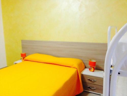 a yellow bedroom with a bed and a chair at Red Stone in Diamante