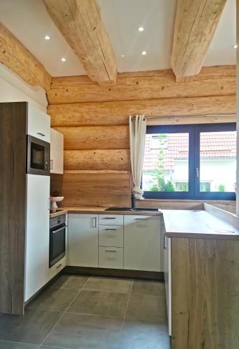 a kitchen with white appliances and a wooden ceiling at DAS Chalet mit Schlossblick in Wernigerode in Wernigerode