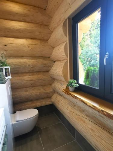 a wooden bathroom with a toilet and a window at DAS Chalet mit Schlossblick in Wernigerode in Wernigerode