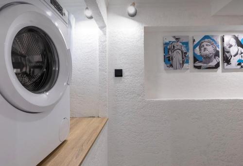 una lavadora en una habitación con cuadros en la pared en VIP apart 626, en Tiflis