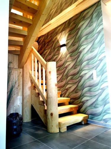 a wooden staircase in a room with a stone wall at DAS Chalet mit Schlossblick in Wernigerode in Wernigerode