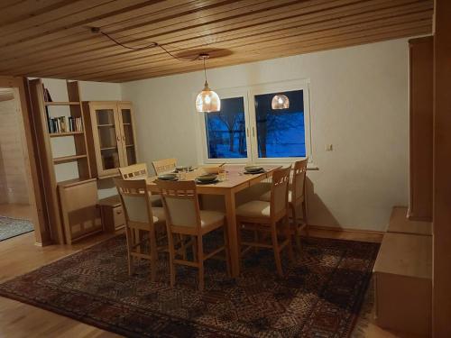 a dining room with a wooden table and chairs at Allgäu Bergblick in Leutkirch im Allgäu