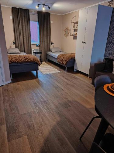una camera d'albergo con due letti e un divano di Stuga utanför Skövde 3 a Skövde