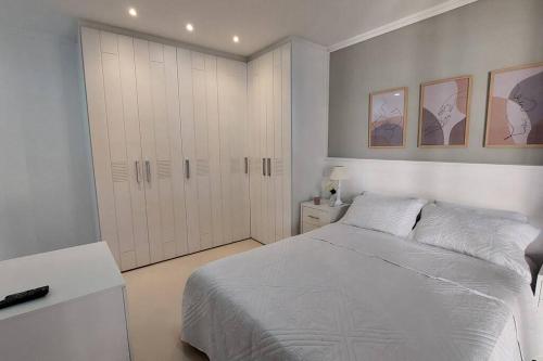 Un dormitorio blanco con una cama y un armario. en Apartamento aconchegante., en Río de Janeiro