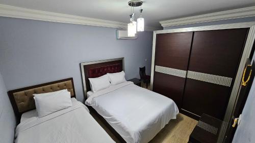 a bedroom with two beds and a sliding door at Welcome sea view - families only in Alexandria