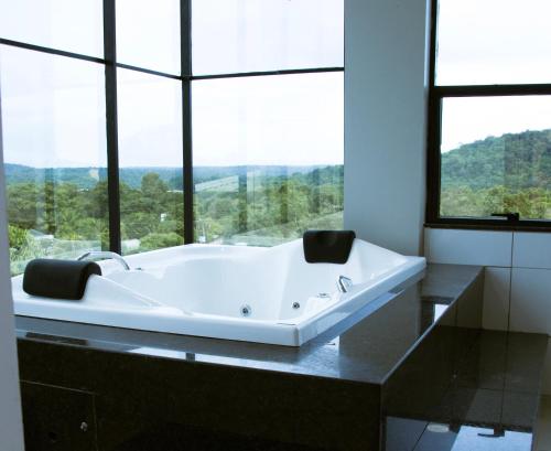 un bagno con vasca e ampia finestra di HOTEL TERRA NATIVA ad Alter do Chão