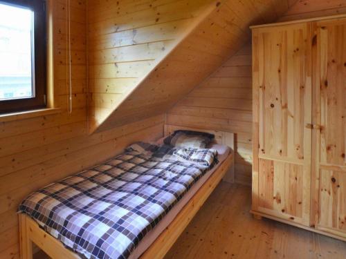 a bed in the attic of a log cabin at Holiday houses close to the beach, Siano ty in Sianozety