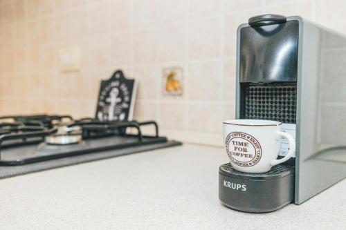 a coffee cup sitting on a counter next to a microwave at Case Vacanze Il Sogno 2 in Porto Pino