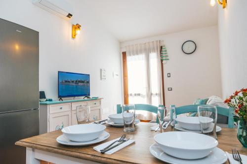 einem Esstisch mit weißen Schalen und Tellern in der Unterkunft Case Vacanze Il Sogno 2 in Porto Pino