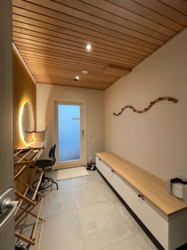 Habitación con techo de madera y escritorio. en Villa Golden House en Rovaniemi