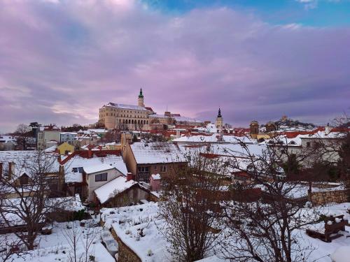 a city with snow covered roofs and buildings at Pension Sebastian in Mikulov