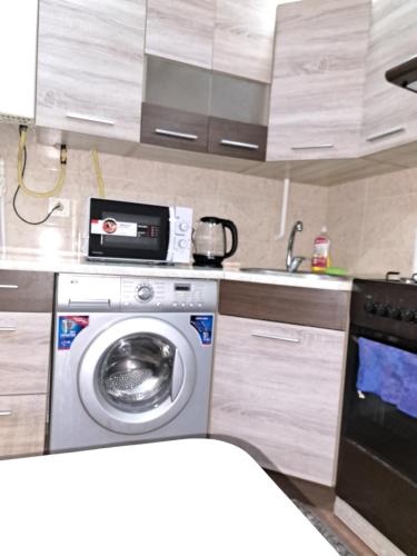 a kitchen with a washing machine and a sink at Сдаётся почасово, посуточно квартира in Edineţ