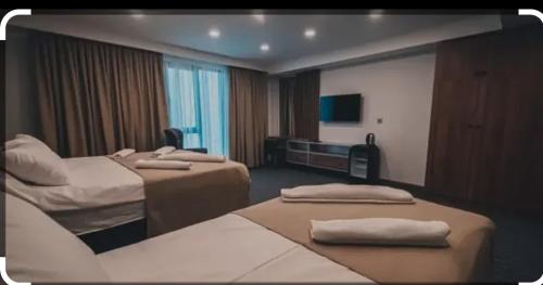 a hotel room with two beds and a television at Beni Lexury Katyora in Unye
