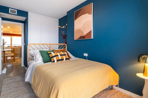a bedroom with blue walls and a bed at Gran Canet 2BR! Walk to Beach, Sea View, Sauna & Gym in Canet de Berenguer