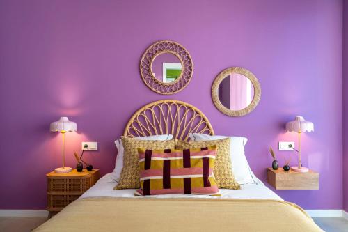a purple bedroom with a bed and two mirrors at Gran Canet 2BR! Walk to Beach, Sea View, Sauna & Gym in Canet de Berenguer