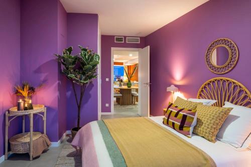 a purple bedroom with a bed and a mirror at Gran Canet 2BR! Walk to Beach, Sea View, Sauna & Gym in Canet de Berenguer
