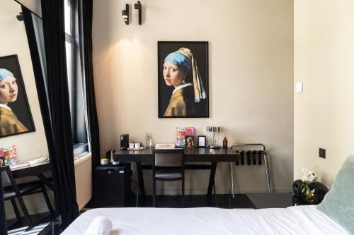 a bedroom with a table with a painting of a woman at Museum Suites in Antwerp