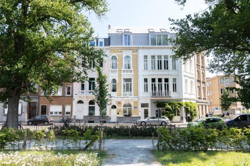 a large white building with cars parked in front of it at Museum Suites in Antwerp
