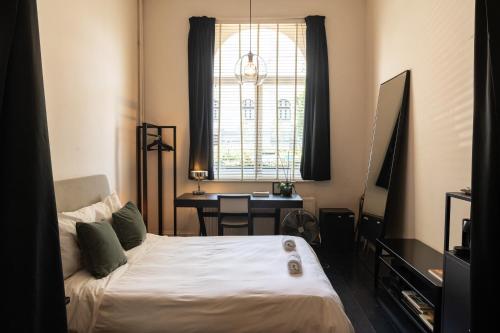 1 dormitorio con cama, escritorio y ventana en Museum Suites, en Amberes