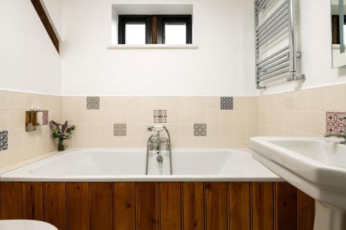 y baño con bañera y lavamanos. en The Cart House en Southampton