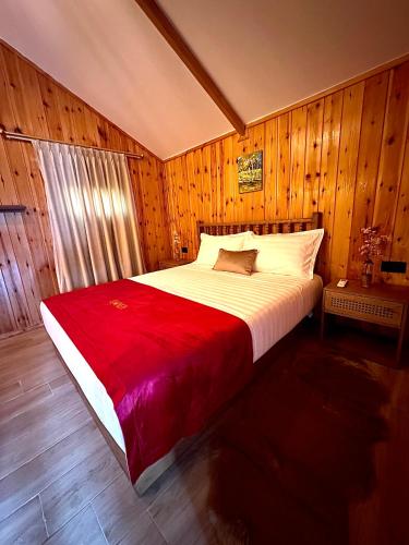 a bedroom with a large bed with a red blanket at Flumen Park in Tirana